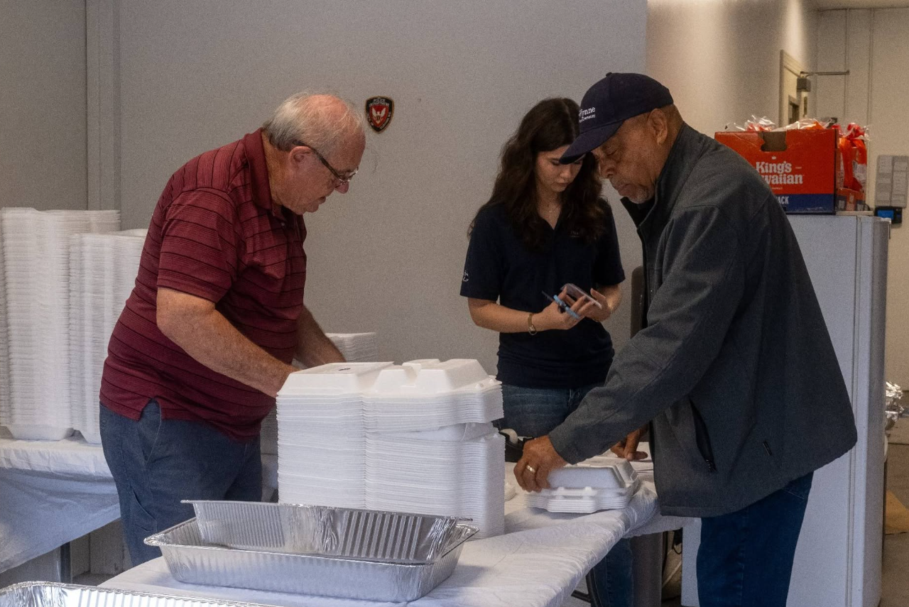 Larry, Jayden, and Ronald prepping to deliver plates of BBQ to local churches. 