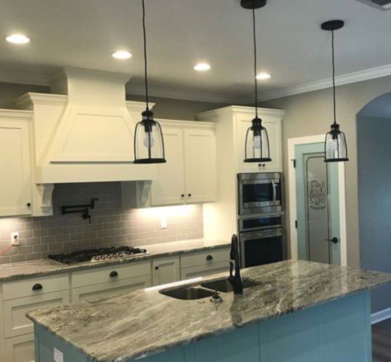 A kitchen with white cabinets and granite counter tops