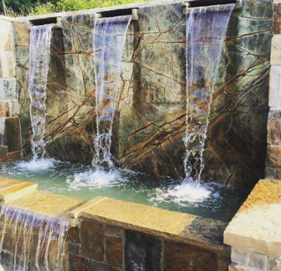 A waterfall is surrounded by a stone wall
