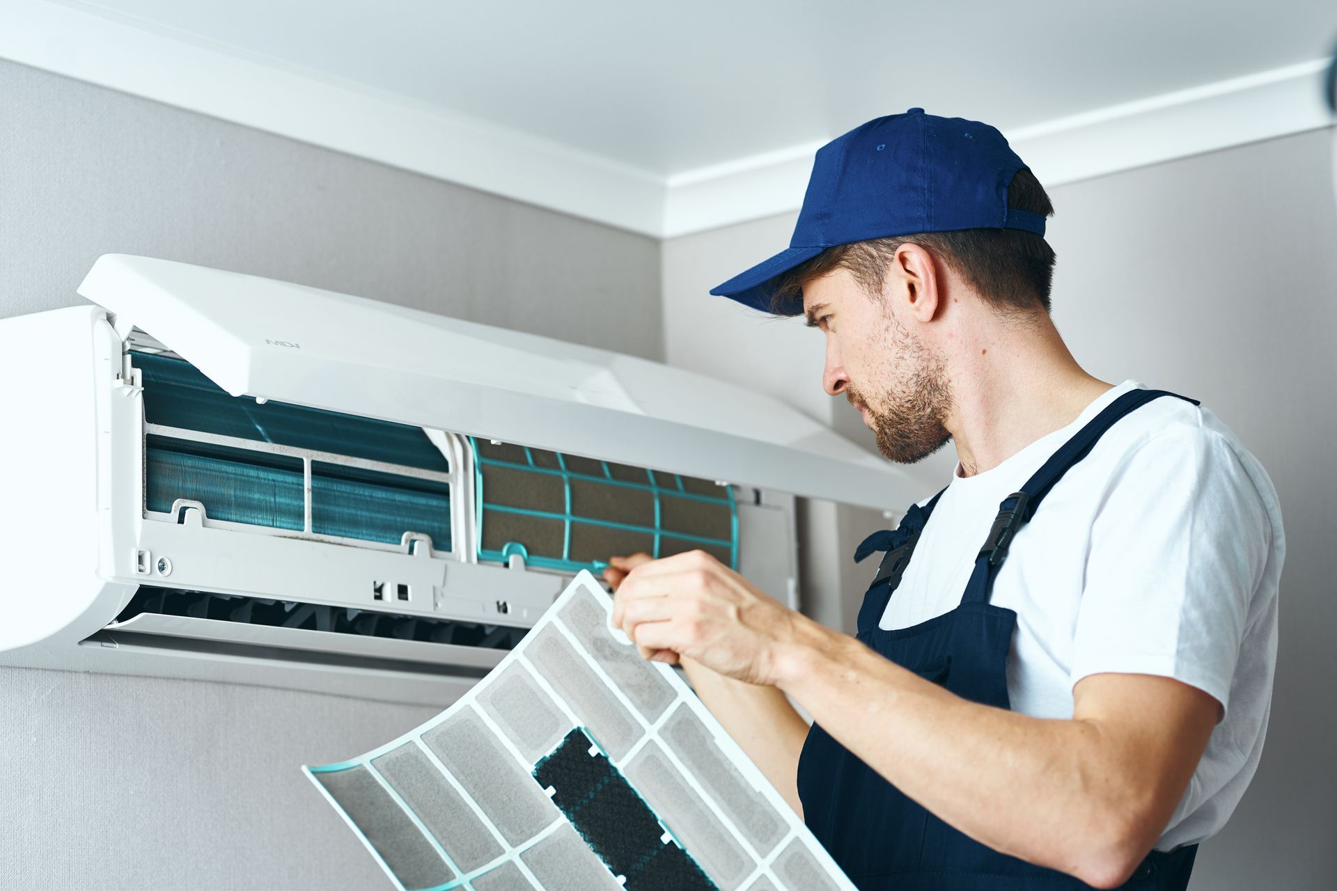 Man Cleaning the Air Conditioner — Carriere, MS — Deluxe A/C & Heat LLC