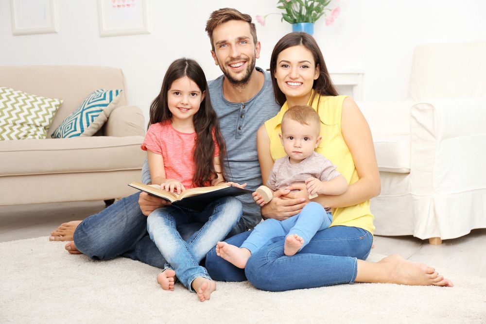 Family with Children Sitting on A Clean Carpet