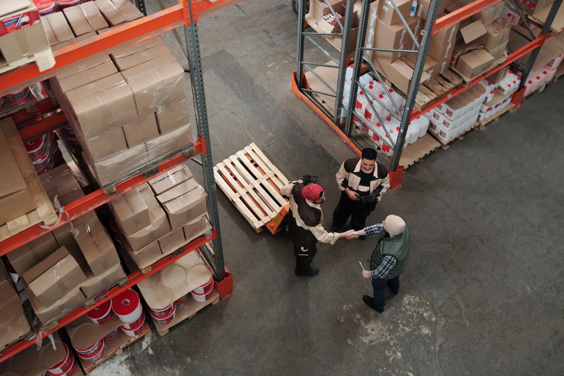 A group of people are shaking hands in a warehouse.