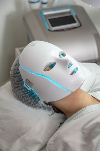 Persona usando traje azul de presoterapia en una camilla, con texto promocional en español.