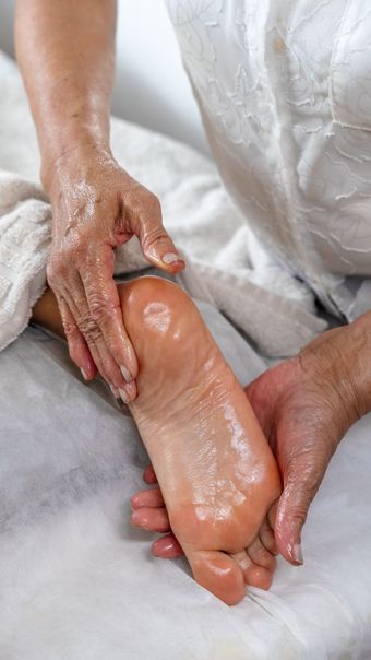 Masajista trabajando en la espalda de una persona en un spa, con texto en español superpuesto que dice “VOLVÉ A SENTIRTE VOS”.