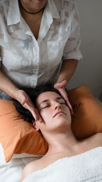 Mujer recibiendo un tratamiento facial con una mano enguantada de azul, texto superpuesto: “MUCHOS TRATAMIENTOS”