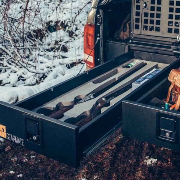 Ett vapenfack med två gevär liggandes i.