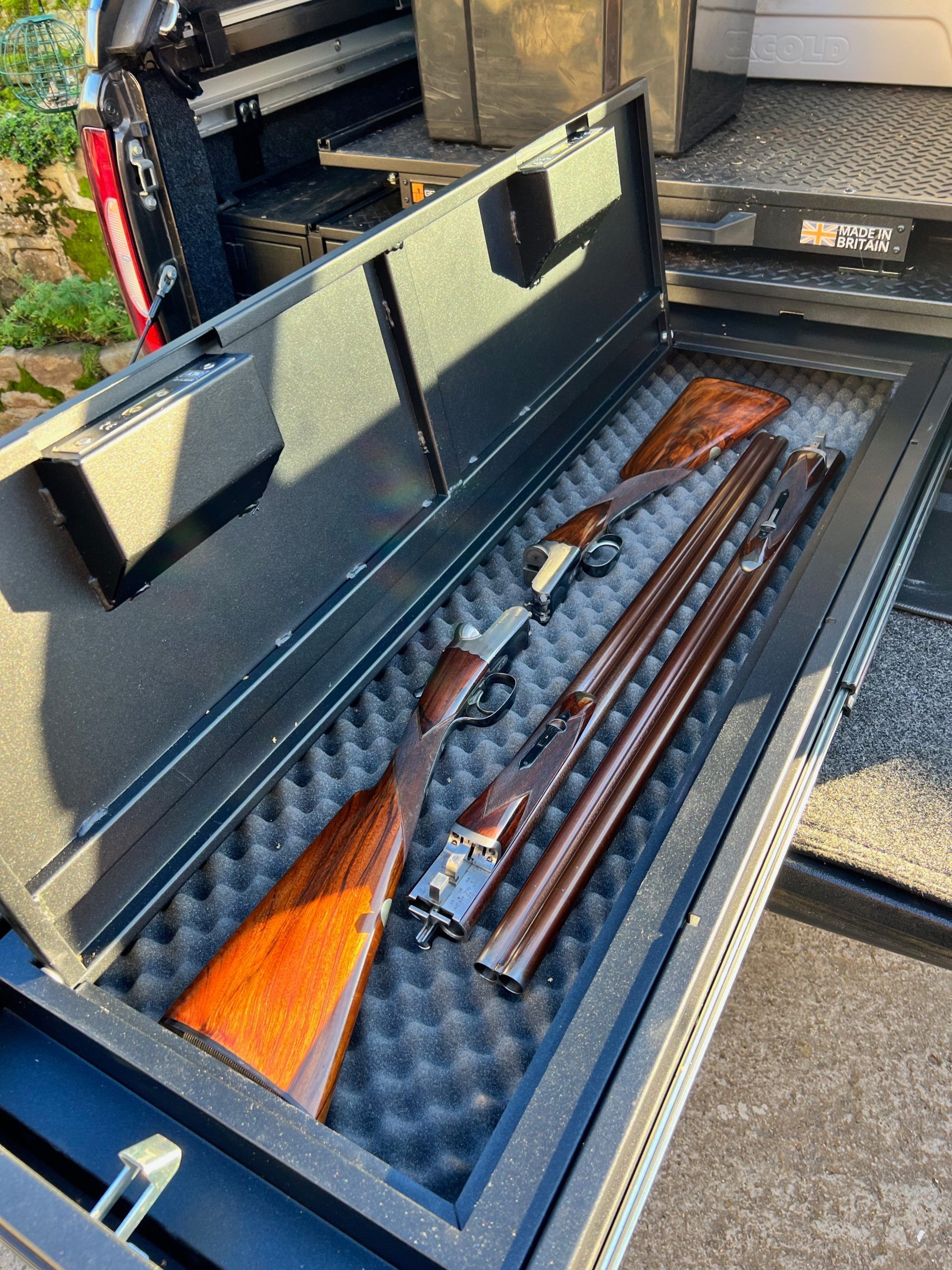 Två hagelgevär sitter i ett skumfodral i ett vapenfack.