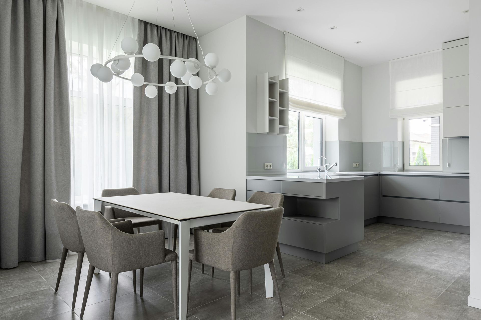 Modern living room with fireplace, open to kitchen. Neutral colors, light wood floors, stylish decor.