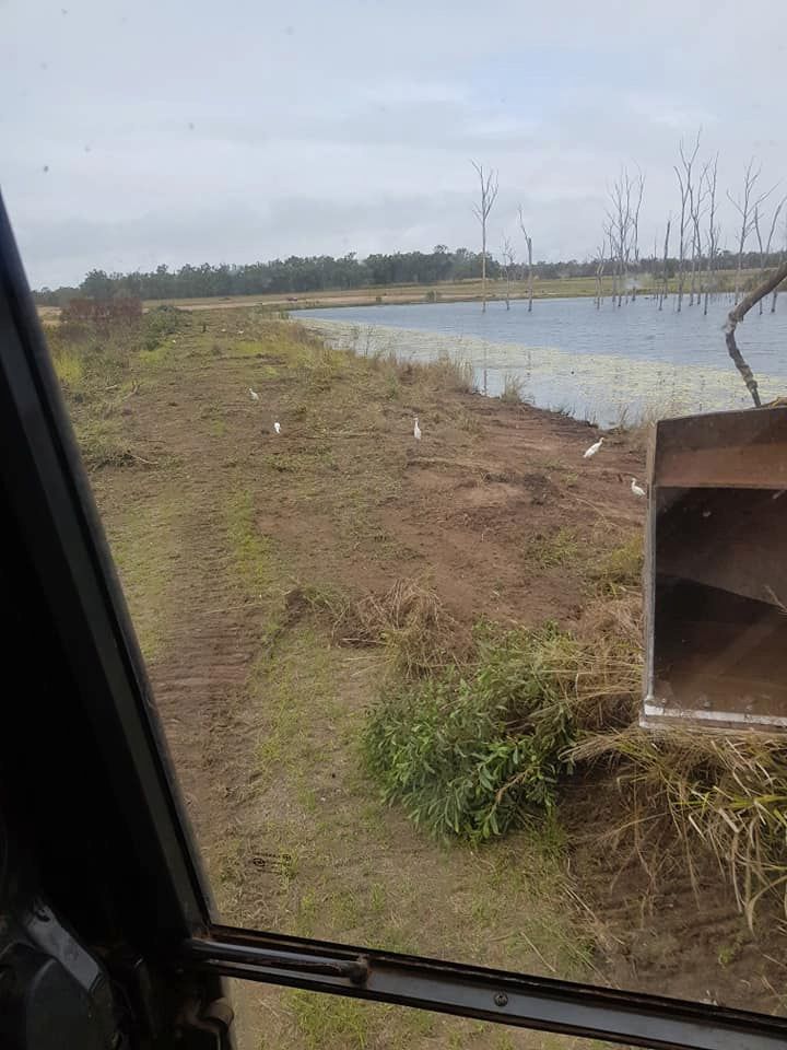 A Truck is Driving Down a Dirt Road Next to a Body of Water — B E Laser Levelling QLD in Hervey Bay, QLD