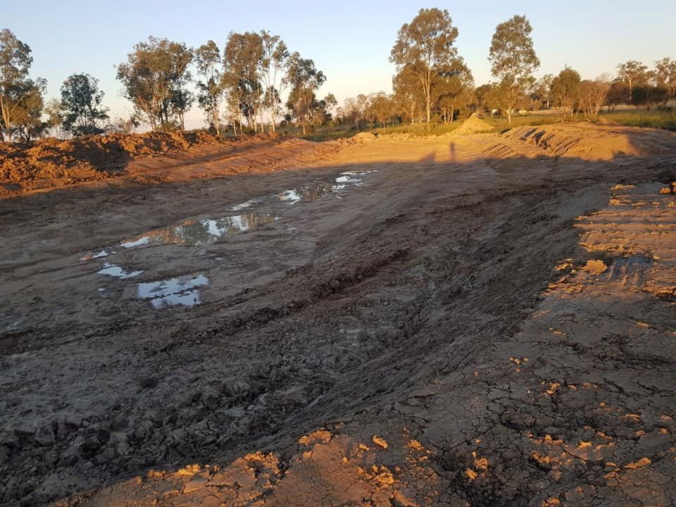 A Muddy Field With Trees in the Background — B E Laser Levelling QLD in Gympie, QLD