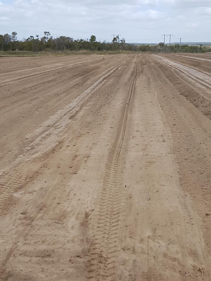 A Dirt Road With Tire Tracks on It Going Through a Field — B E Laser Levelling QLD in Bucca, QLD