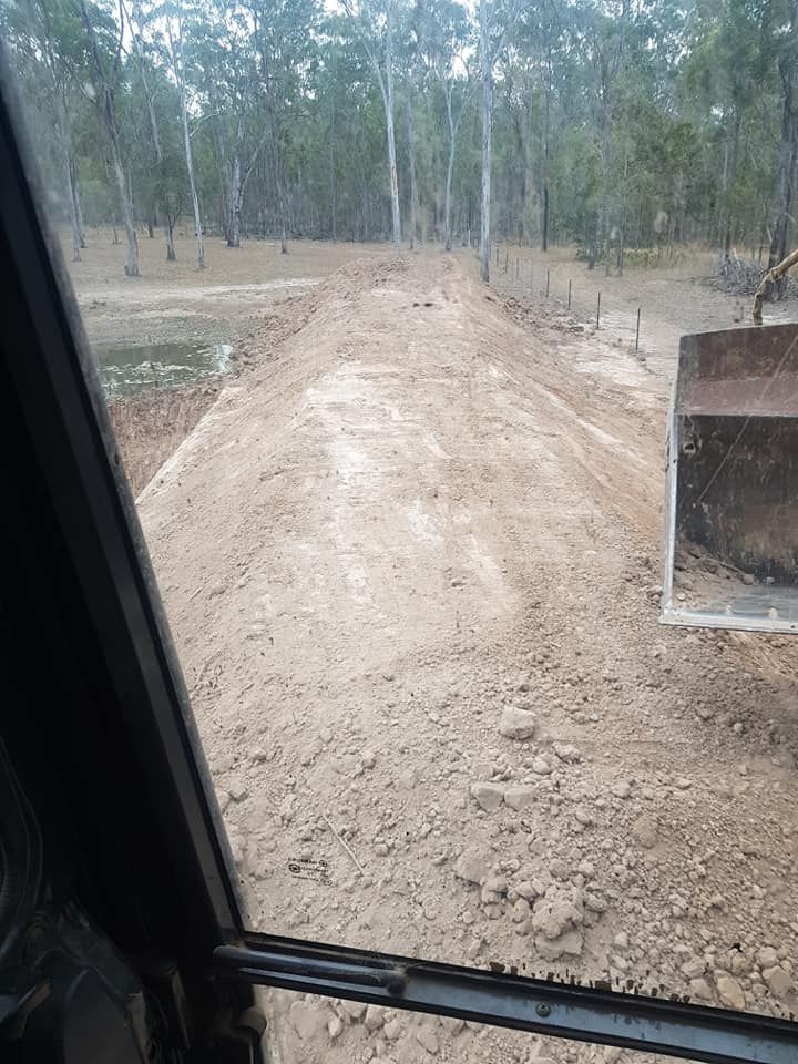 A Bulldozer is Moving Dirt on a Dirt Road — B E Laser Levelling QLD in Gympie, QLD