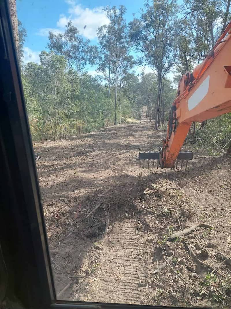 A Large Orange Excavator is Sitting in the Middle of a Dirt Field — B E Laser Levelling QLD in Bucca, QLD