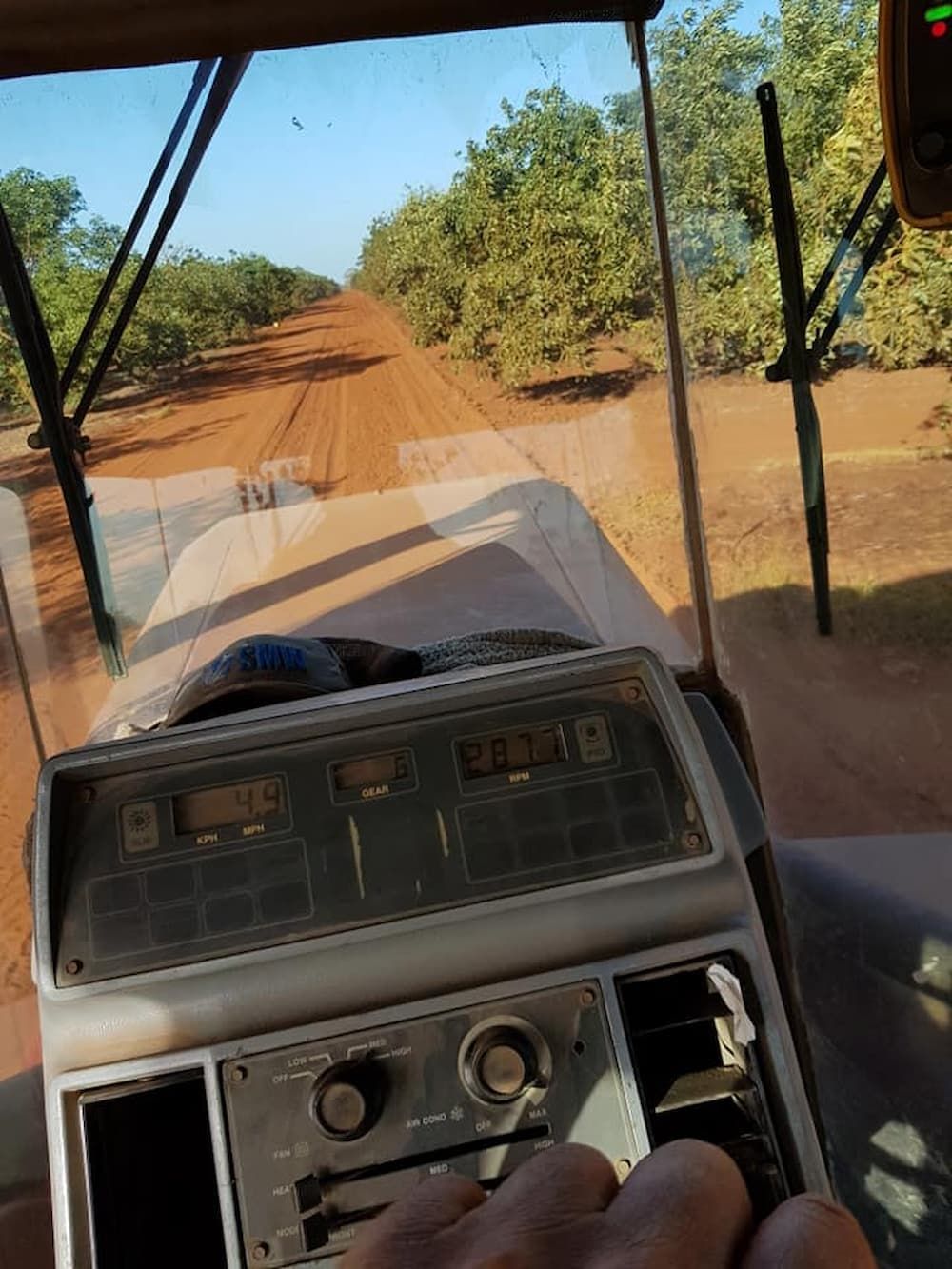 A Person is Driving a Tractor on a Dirt Road — B E Laser Levelling QLD in Bucca, QLD