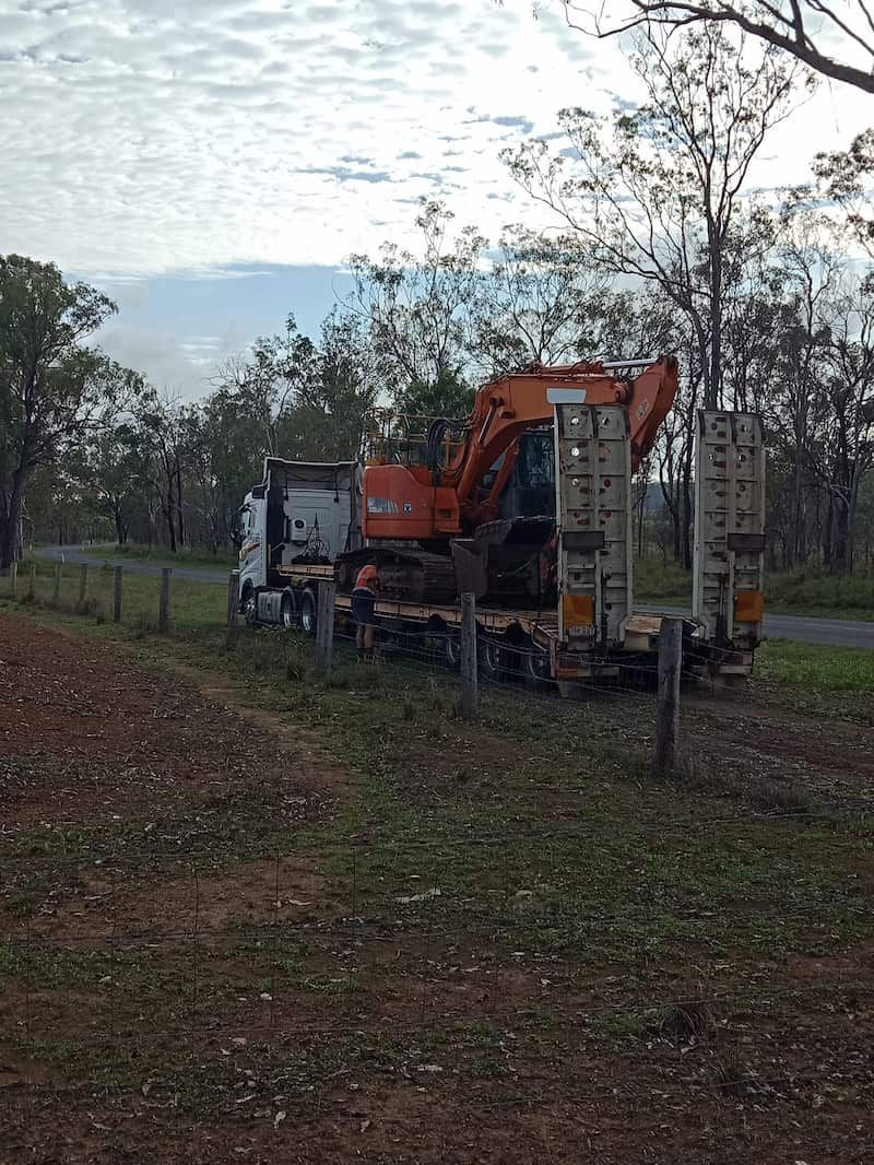 A Tractor is Driving Down a Dirt Road — B E Laser Levelling QLD in Bucca, QLD