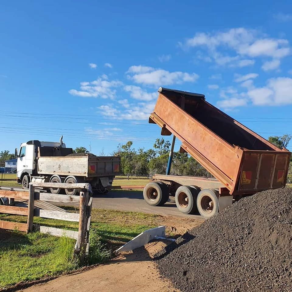 A Dump Truck is Sitting on Top of a Pile of Gravel — B E Laser Levelling QLD in Bucca, QLD