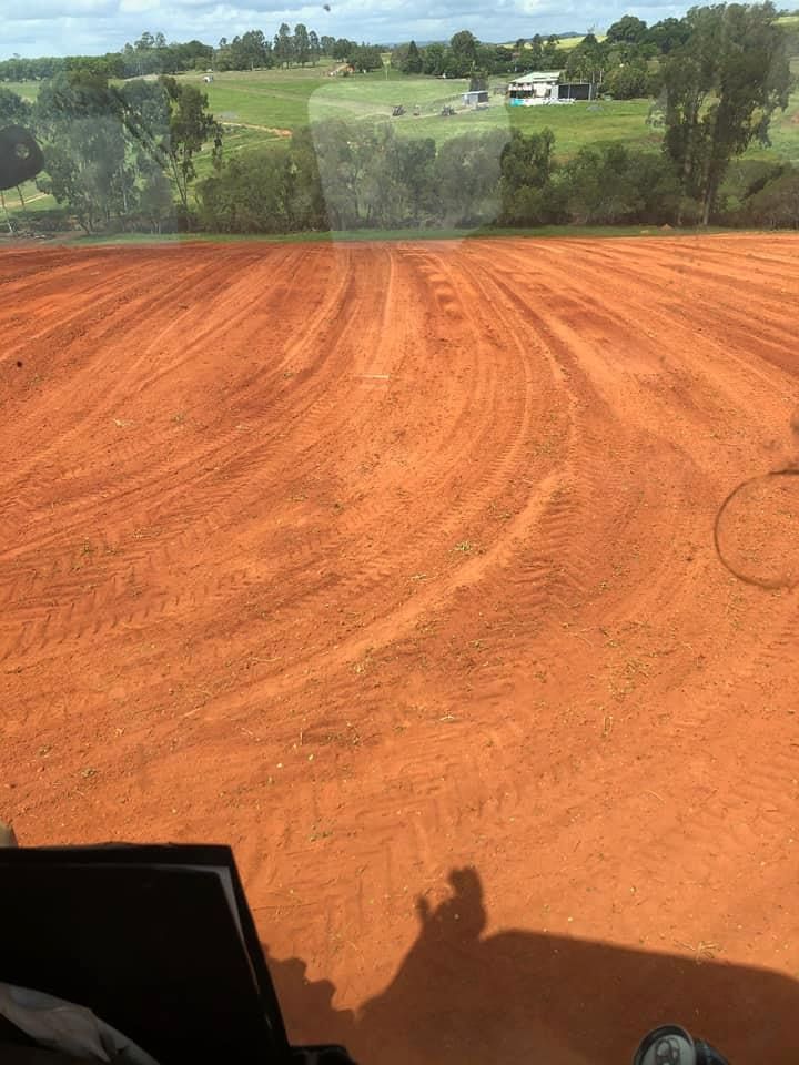 A Person is Driving a Tractor on a Dirt Road — B E Laser Levelling QLD in Childers, QLD