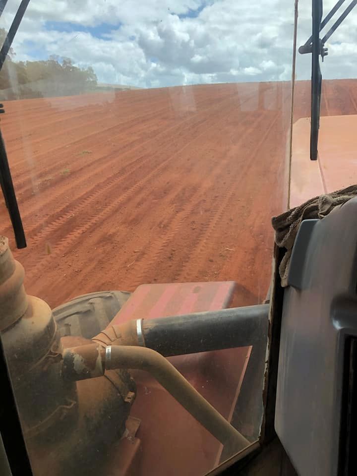 A Tractor is Driving Through a Dirt Field — B E Laser Levelling QLD in Childers, QLD