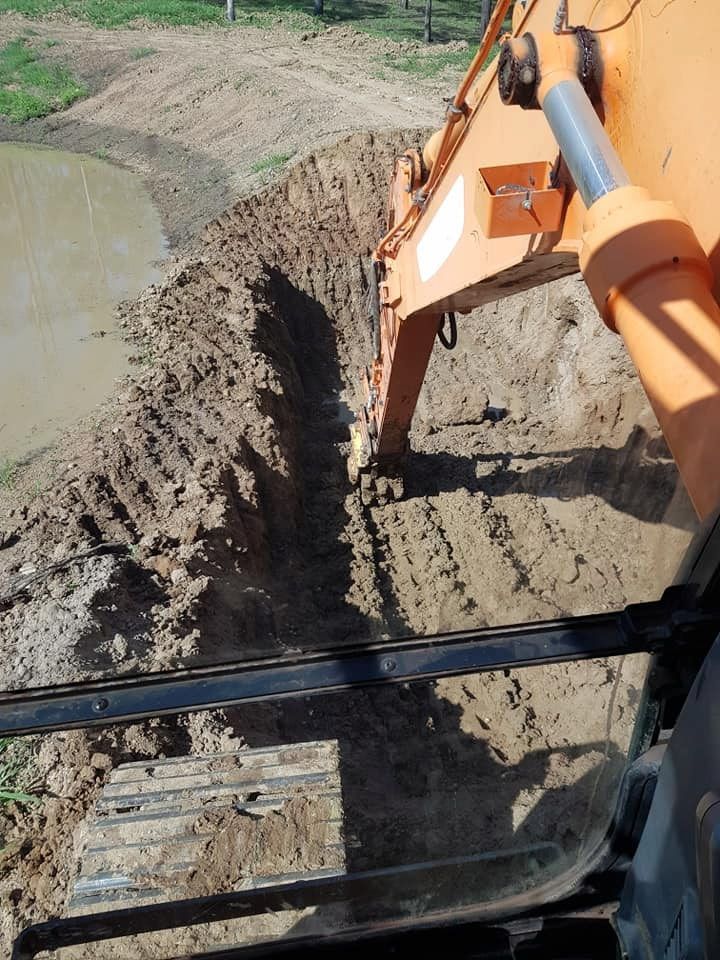 A Bulldozer is Digging a Hole in the Dirt — B E Laser Levelling QLD in Bucca, QLD