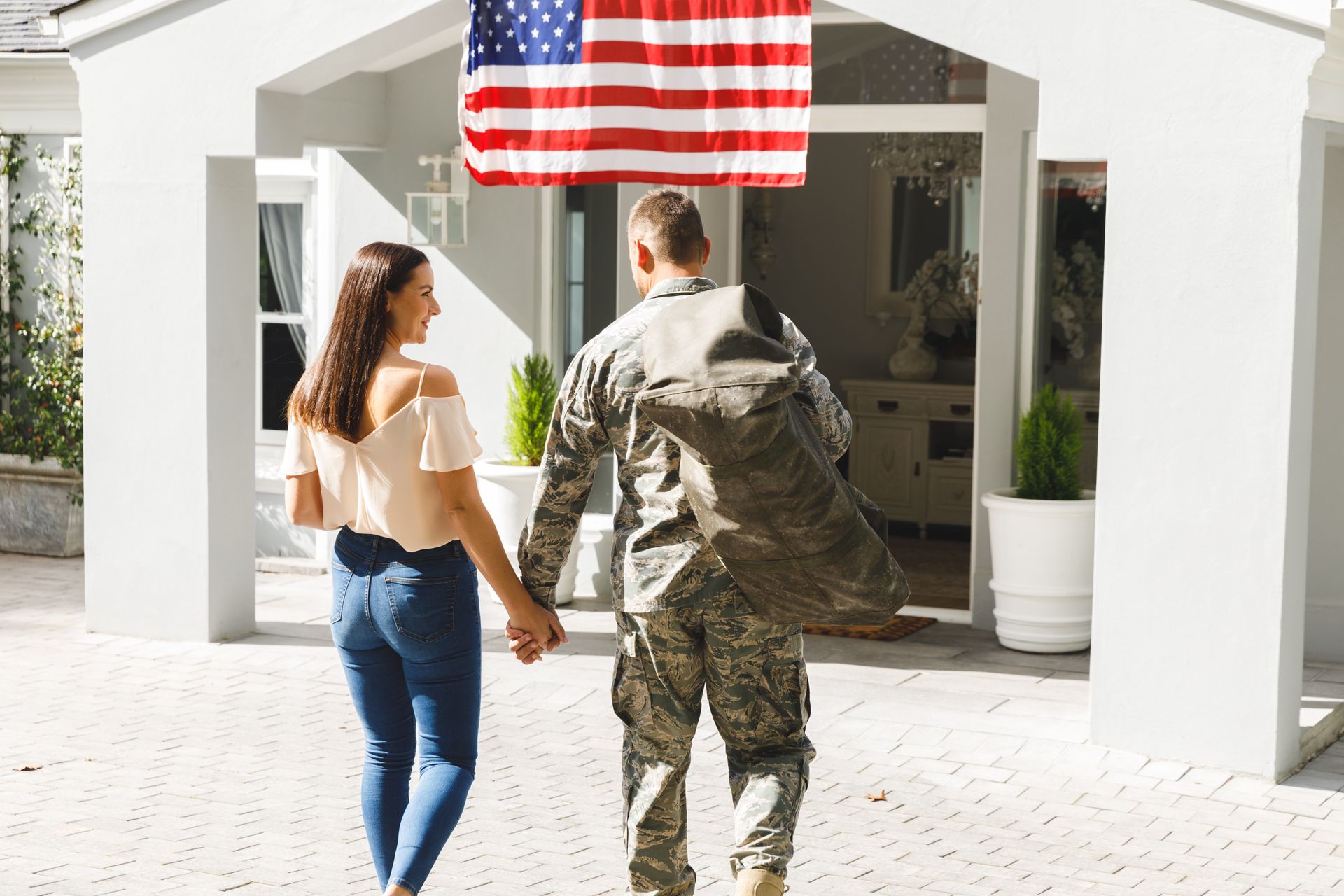 A man and a woman in military uniforms are standing next to each other and looking out of a window.