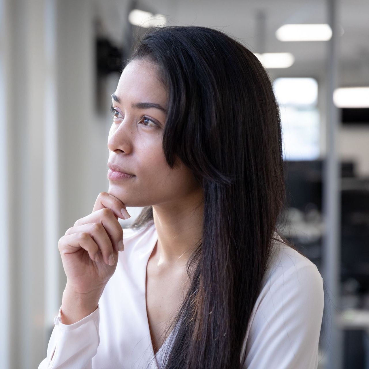 A man in a military uniform is sitting in a wheelchair holding his head.
