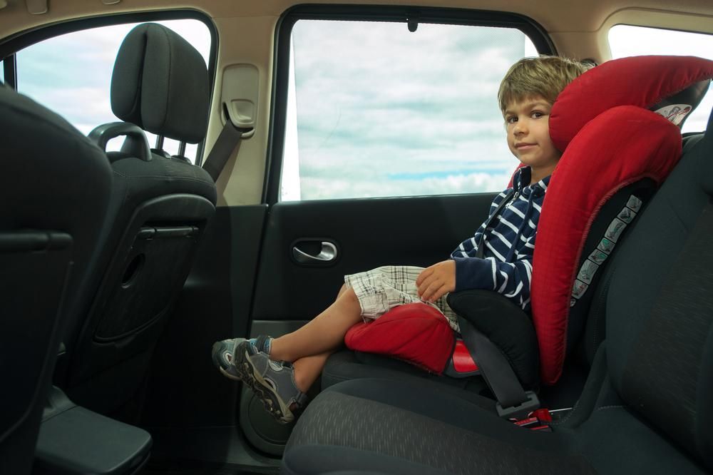 A Young Boy Is Sitting In The Back Seat Of A Car — Dancers Car Care In Ballina, NSW