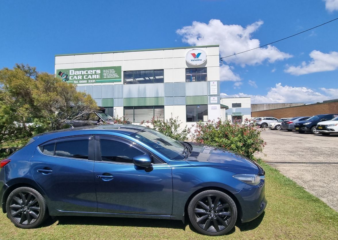 A Blue Car Is Parked In Front Of A Building — Dancers Car Care In Ballina, NSW