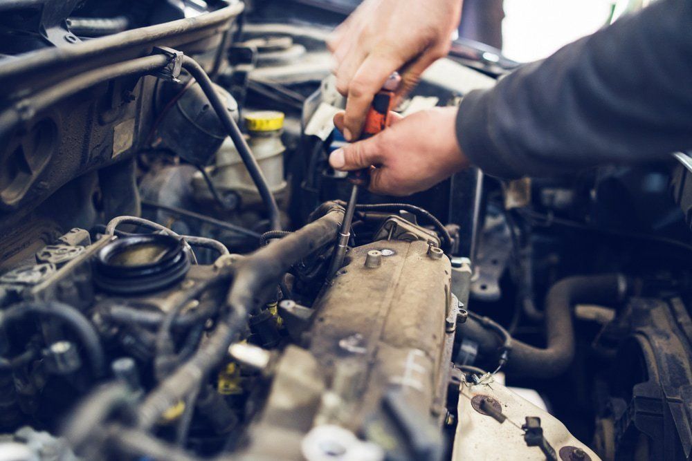 A Man Is Working On The Engine Of A Car With A Wrench — Dancers Car Care In Ballina, NSW