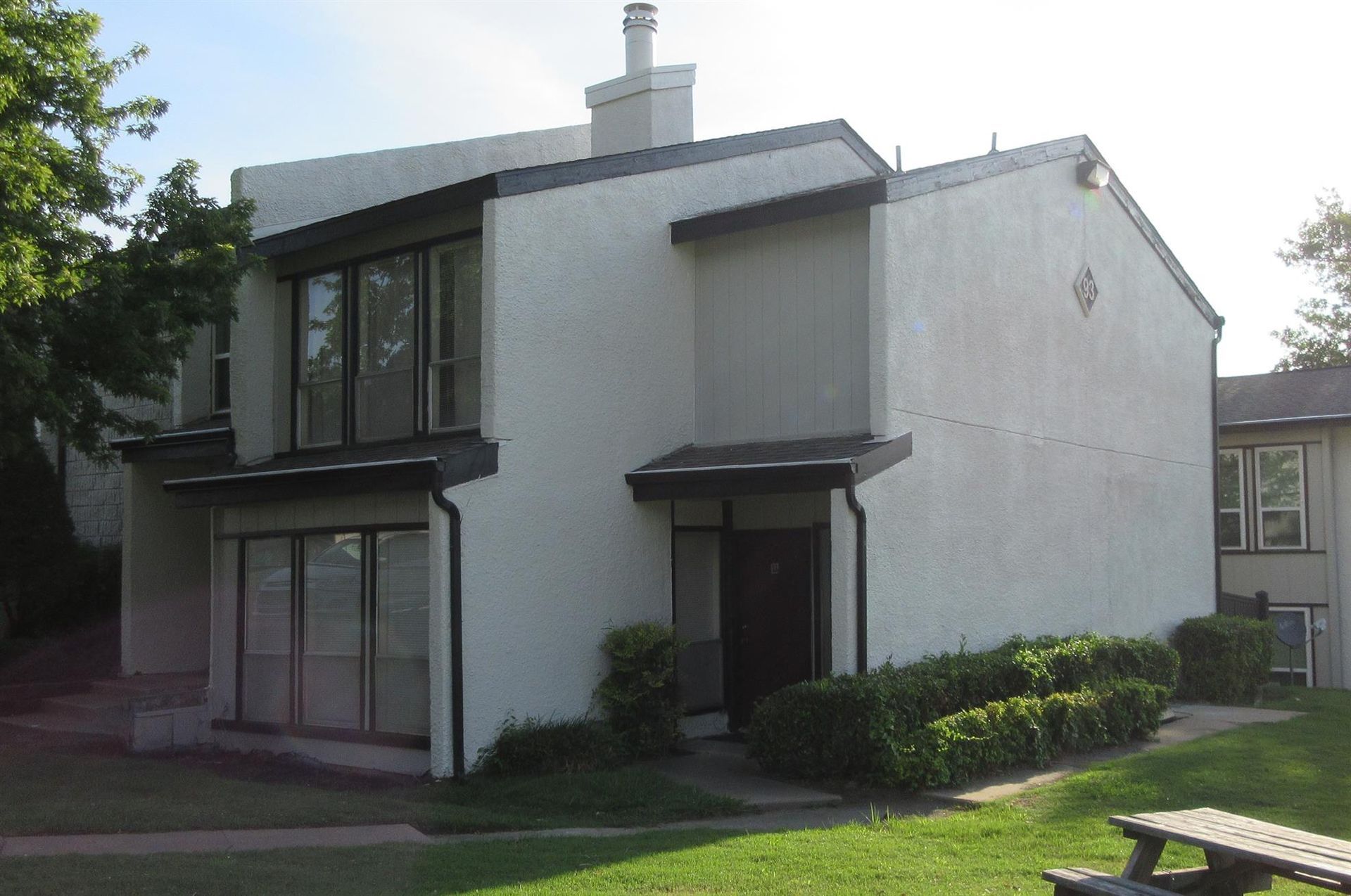 A white house with a picnic table in front of it