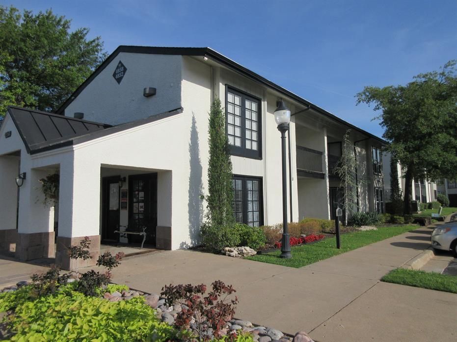 A large white apartment building with a black roof