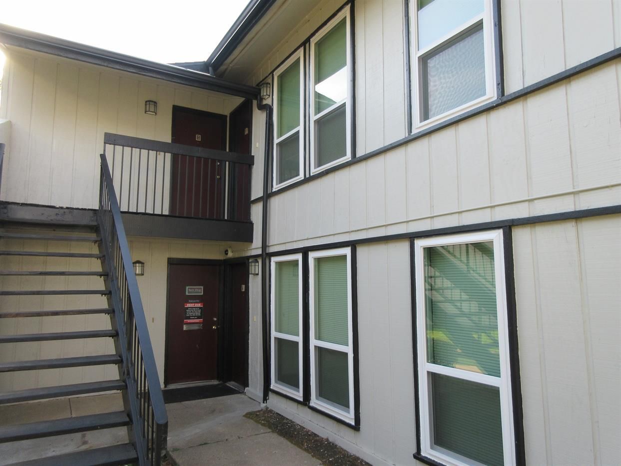 A building with stairs leading up to the second floor and a balcony.
