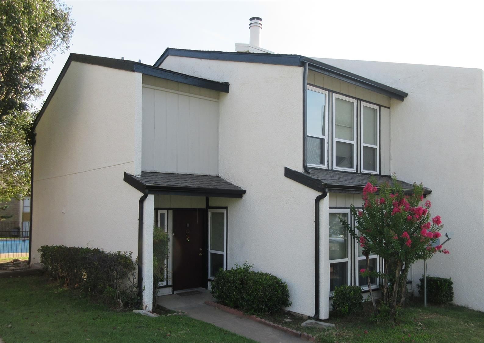 A white house with a black roof and many windows