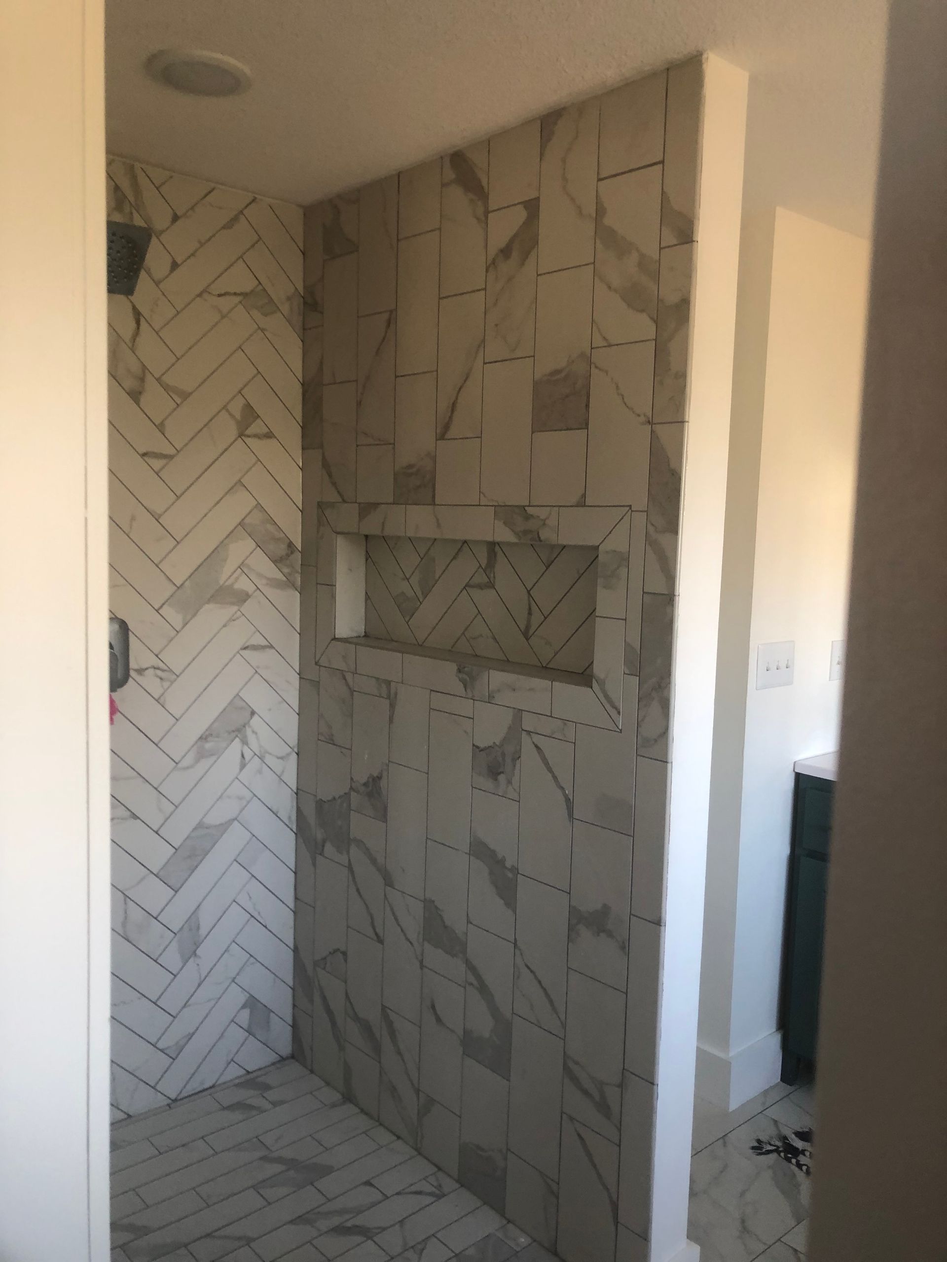 Custom Shower Niche With Herringbone Tile Built by Hombs Custom Homes in Mid-Missouri.