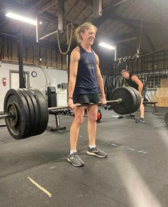 A man is lifting a barbell in a gym.