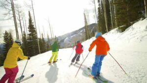 A group of people are skiing down a snow covered slope.