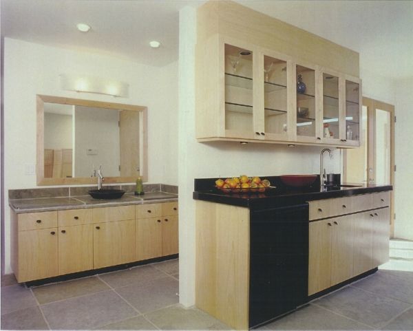 A kitchen with wooden cabinets and a black counter top