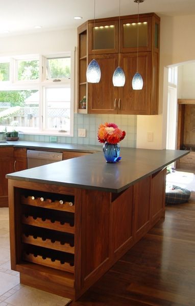 A kitchen with a wine rack and a vase of flowers on the counter