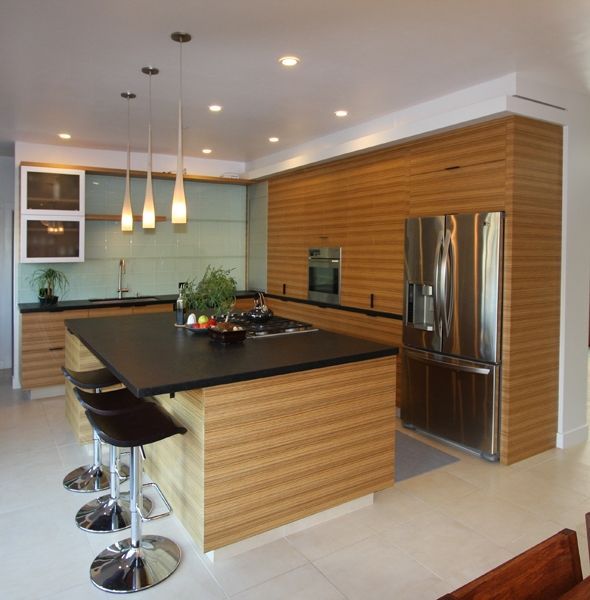 A kitchen with wooden cabinets and a stainless steel refrigerator