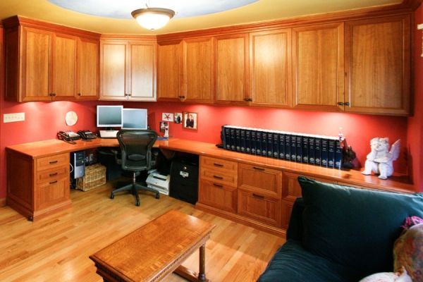 A living room with wooden cabinets and a desk with a computer on it
