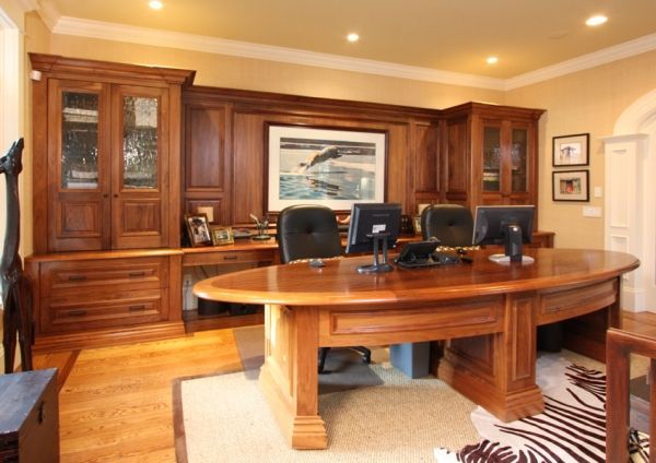 A home office with a large wooden desk and chairs