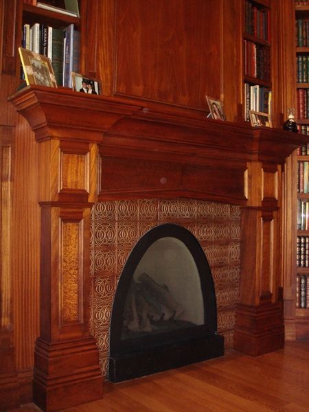 A fireplace surrounded by bookshelves and a wooden mantle