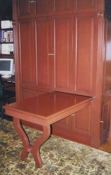 A wooden table that is pulled out of a wall