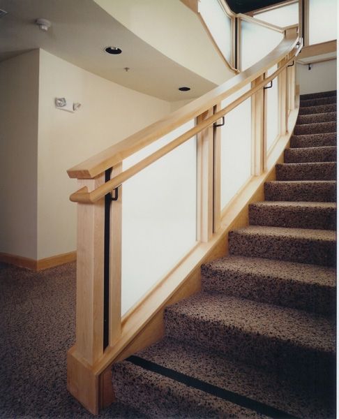 A staircase with a wooden railing and carpeted steps