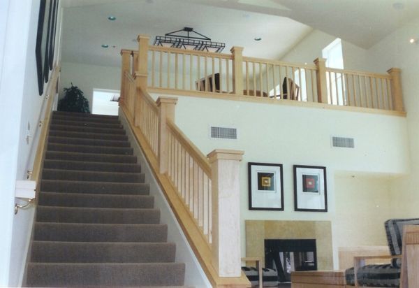 A living room with stairs leading up to the second floor