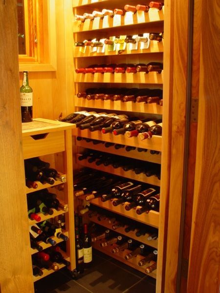 A bottle of wine sits on a counter in a wine cellar