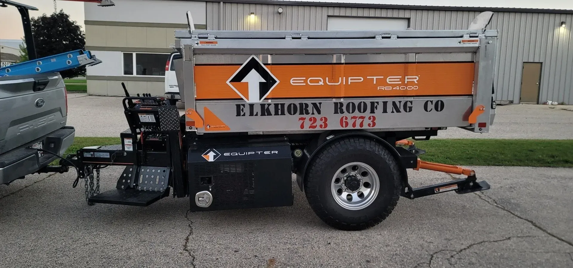 Truck towing a roofing trailer with Elkhorn Roofing Co. logo.