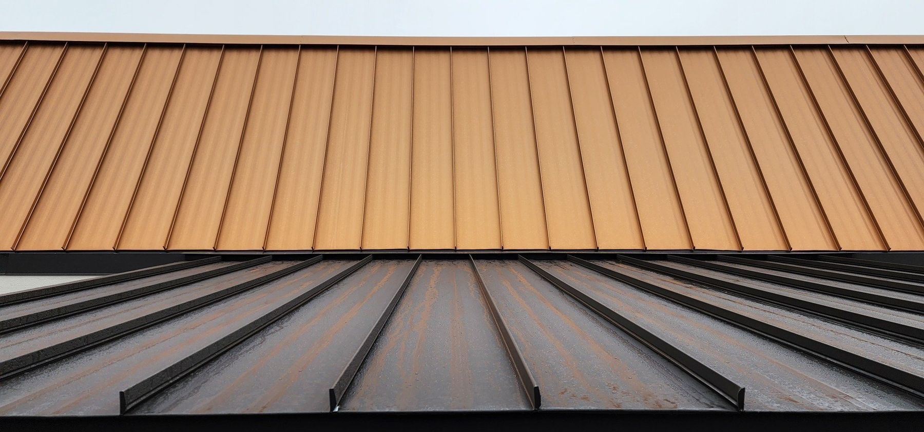 Two-toned metal roof with brown and black sections, with vertical lines.