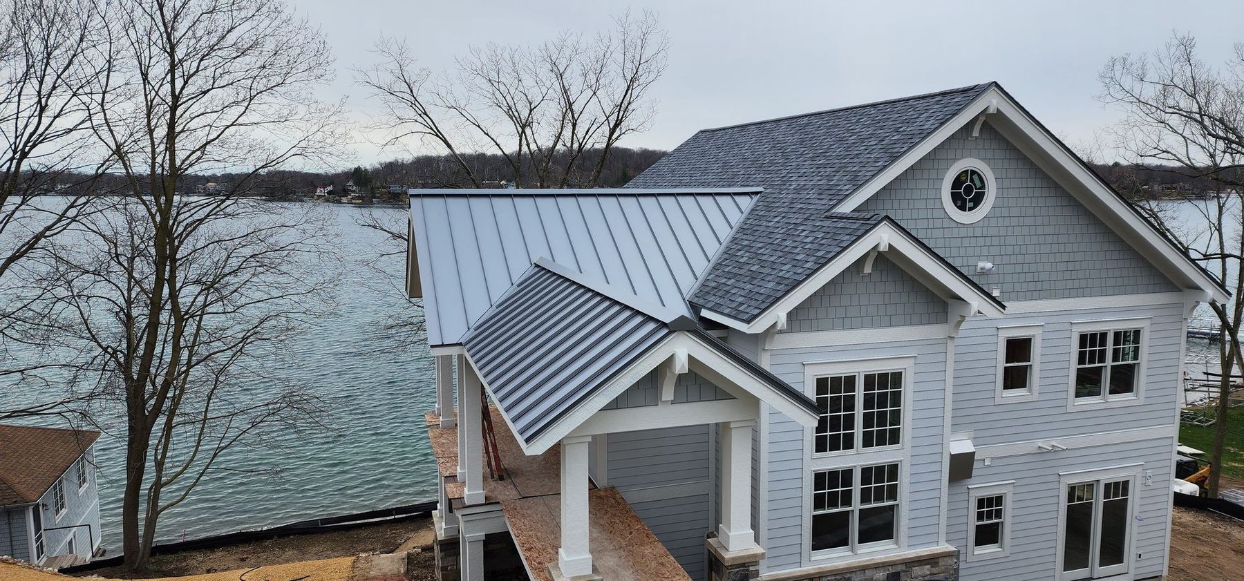 Brick house with beige garage door, arched entry, brown roof, and blue sky. Brick house with beige garage door, arched entry, brown roof, and blue sky.