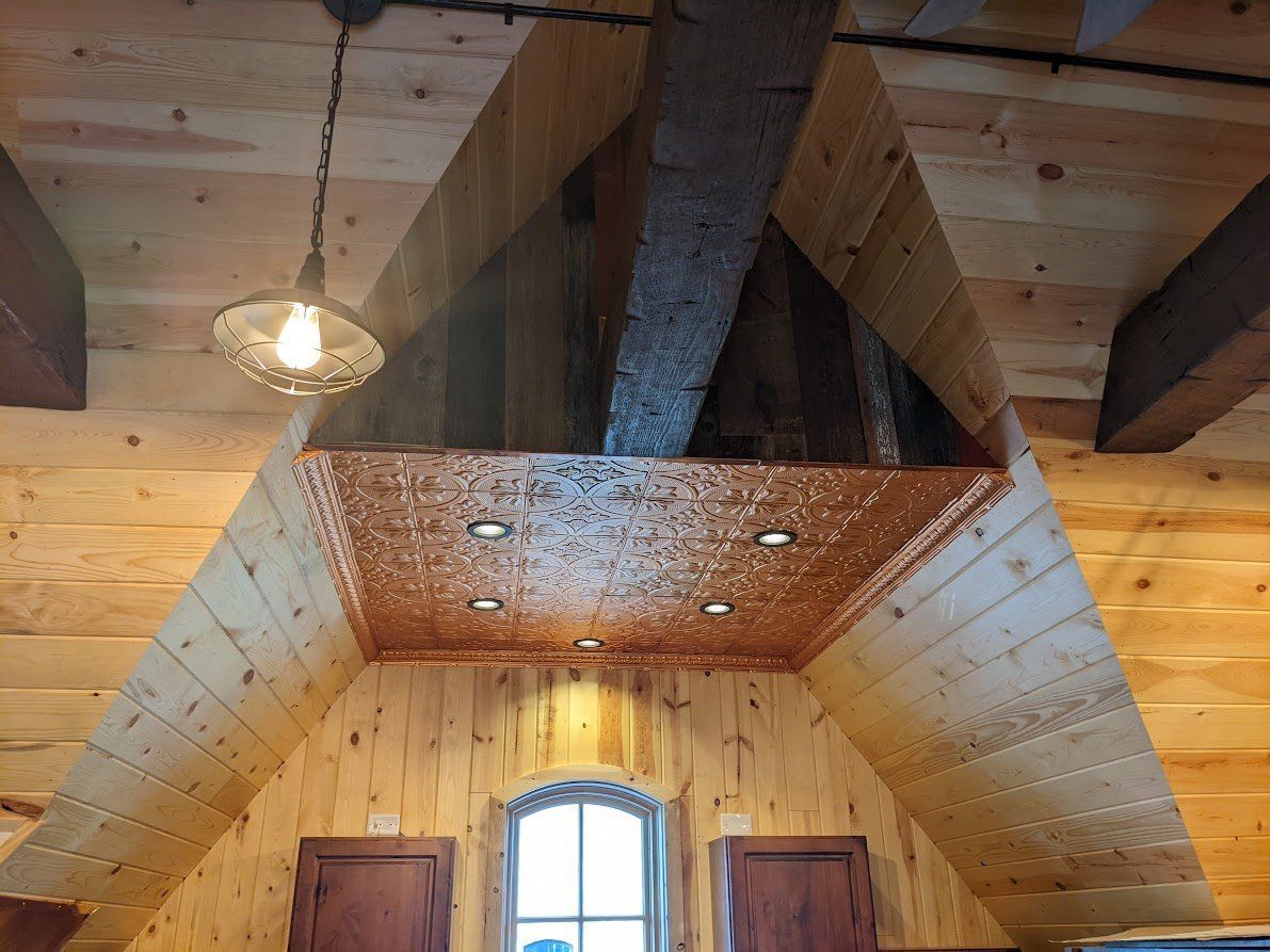 Wooden ceiling with recessed lights, copper panels, and exposed ductwork.