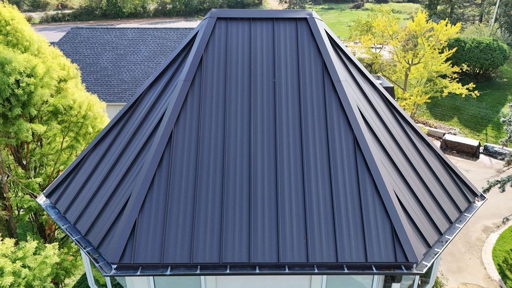 Dark gray metal roof with vertical panels, angled design.
